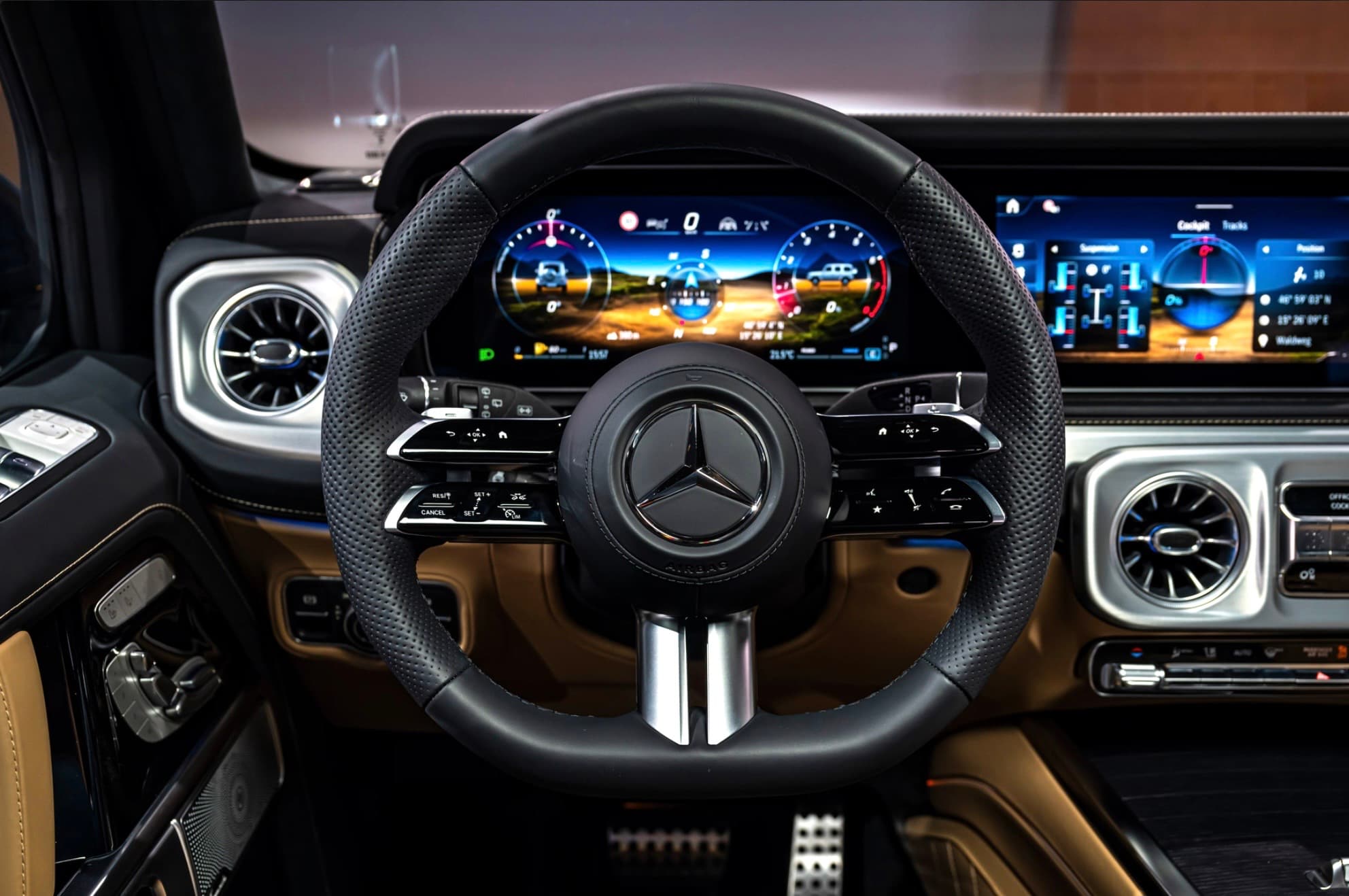 Mercedes-Benz steering wheel and digital dashboard showing off-road performance data in a luxury car.